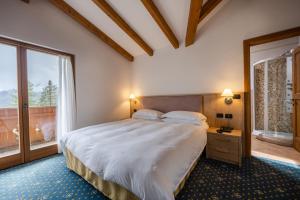 圣马蒂诺-迪卡斯特罗扎Hotel Stalon Alpine Chic的一间卧室设有一张大床和一个窗户。
