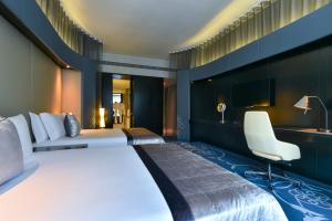 多哈W Doha的酒店客房设有一张大床和一张书桌。