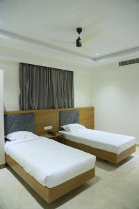 ChittoorRAJA MAHAL的一间卧室设有两张床和窗户。