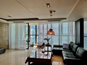 釜山Haeundae Luxury House的带沙发和玻璃桌的客厅