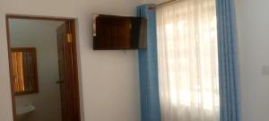 AwasiAster Suites Kisumu的浴室设有窗户、窗帘和镜子