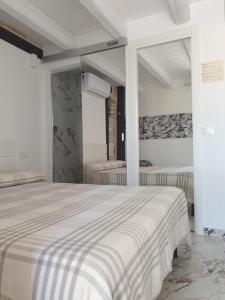 卡斯泰尔菲达尔多La Dolce Vita的一间白色卧室,配有两张床和镜子