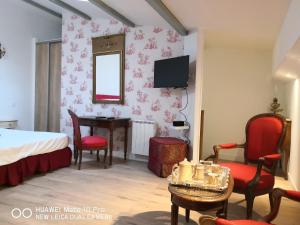 圣洛朗代阿尔布雷圣劳伦酒店的卧室配有一张床和一张桌子及椅子