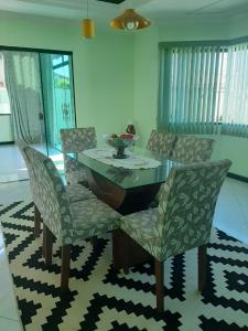大伊瓜巴Linda casa pertinho da Lagoa的一间设有玻璃桌和椅子的用餐室