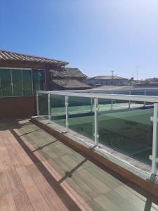 大伊瓜巴Linda casa pertinho da Lagoa的甲板上带有玻璃屋顶的建筑