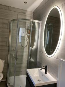 斯旺西Walter Road Holiday Home Swansea - 4 bedrooms的带淋浴、盥洗盆和镜子的浴室