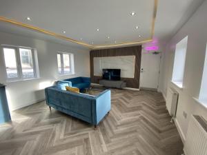 斯旺西Walter Road Holiday Home Swansea - 4 bedrooms的客厅配有蓝色的沙发和电视