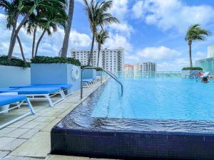 劳德代尔堡Luxury Well stocked SE Corner 2BR W Fort Lauderdale w Great Ocean Views的棕榈树建筑屋顶上的游泳池