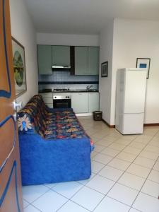 圣贝内代托-德尔特龙托奥特雷马雷住宅酒店的厨房配有蓝色的床和冰箱。