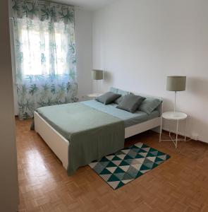 的里雅斯特CASA DENDI的一间卧室设有一张大床和两个窗户。