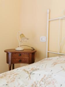 Luci nel Bosco的一间卧室配有一张床和一张带台灯的桌子