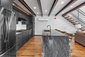 希尔城McGregor & Main - Luxury Lofts的厨房配有黑色橱柜和花岗岩台面