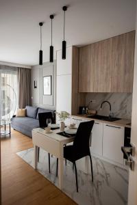 凯尔采EXCLUSIVE Apartamenty Lotnicza , PARKING的厨房以及带桌椅的起居室。