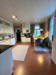 萨翁林纳Huvila Kyrönniemi的厨房以及带桌椅的起居室。