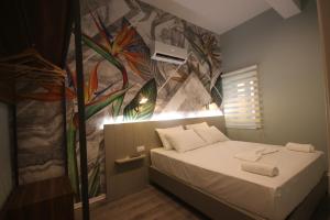 希马拉Alyvia Rooms的一间设有一张壁画床的房间