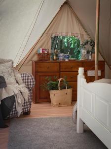 希恩Idyllisk glamping rett ved elven的一间卧室配有一张床和一个帐篷