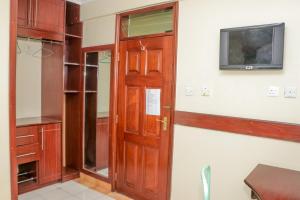 内罗毕KAP Guest House的一间设有门的房间和墙上的电视