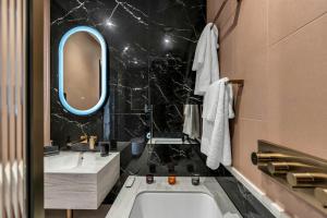 爱丁堡Roomzzz Edinburgh的带浴缸、水槽和镜子的浴室