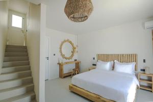 帕罗斯岛Lyra Sunset Suite的一间白色的卧室,配有床和楼梯