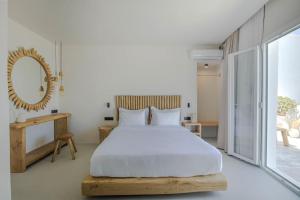 帕罗斯岛Lyra Sunset Suite的一间卧室配有一张大床和镜子