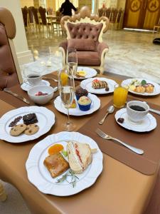 格拉玛多Chocoland Hotel Gramado soft opening的餐桌,带食物盘和酒杯
