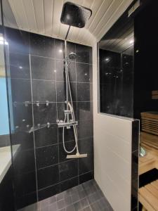 图尔库Saunallinen rivitalon pääty asunto kahdella terassilla的浴室设有黑色瓷砖淋浴。