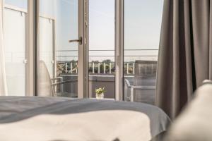 比苏姆Küstenperle Strandhotel & Spa的一间卧室设有一张床和一个大窗户