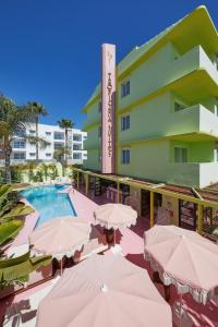 普拉亚登博萨Tropicana Ibiza Suites - Adults Only的配有遮阳伞和游泳池的酒店