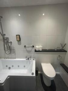 牛津The Highwayman Hotel的浴室配有白色浴缸和卫生间。