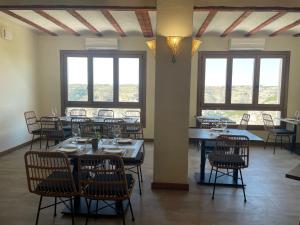 阿尔卡拉德尔胡卡尔Alkalea Hospedería的用餐室设有桌椅和窗户。