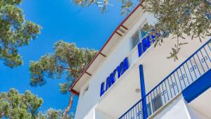 KaradereLikya Inn的白色的建筑,拥有蓝色的窗户和树木