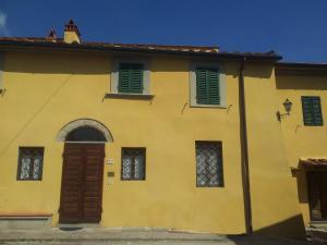 卡尔米尼亚诺弗里吉奥纳亚农家乐的黄色的房子,上面有绿色百叶窗
