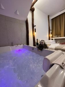 欧巴涅Tamarin & Capucin Suite Balnéo的浴室配有充满蓝色水的浴缸。