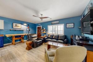 凤凰城Desert Haven Hideaway的客厅拥有蓝色的墙壁和皮革家具。