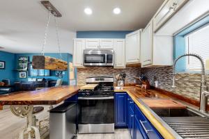 凤凰城Desert Haven Hideaway的厨房配有蓝色橱柜和木制台面