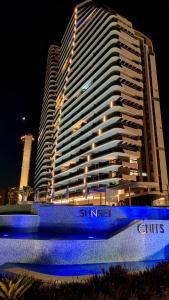 贝尼多姆SUNSET CLIFFS modern apartment的建筑前有蓝色标志的酒店