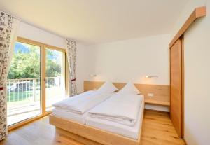万丹斯Landhaus Valfontana的一间卧室设有一张床和一个大窗户