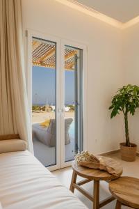 米克诺斯城Aya Sofia Suites的一间卧室配有一张床,享有海滩美景