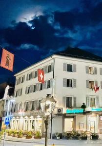 格拉鲁斯Hotel Stadthof Glarus的一座白色的大建筑,上面有红色的十字架