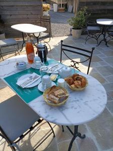 CanapvilleAuberge du Vieux Tour Le Manoir的一张带面包和糕点的白色桌子