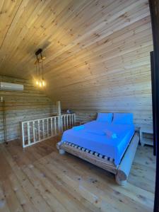 巴统Guest House on Angisa的木制客房内的一间卧室,配有一张床