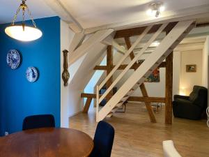 利克维Laterale Residences Riquewihr的一间带木桌和楼梯的用餐室