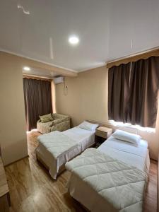 格里戈莱蒂IPPA S PLAZA的酒店客房,配有两张床和椅子