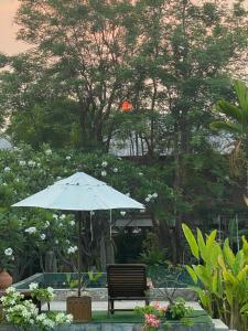 素可泰BaanSuk Sukhothai Resort的花园内带遮阳伞的长凳