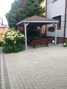 尤斯托尼莫斯基Pokoje Gościnne „IKAR”的凉亭,带长凳和鲜花