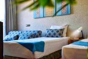 阿加迪尔Route de miel的一间卧室配有两张带蓝白色枕头的床