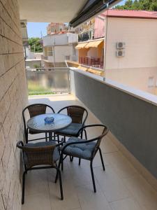 奥米什Omis - private Ensuite room with balcony - hotel style的阳台的天井配有三把椅子和一张桌子