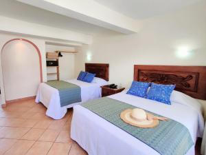 巴亚尔塔港罗西塔酒店 的酒店客房,设有两张床,上面有帽子