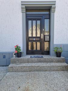MühlauPension Valentina的一座带楼梯和植物的建筑的前门
