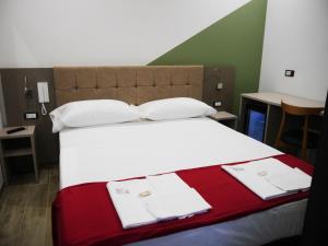 圣乔瓦尼·罗通多HOTEL HOUSE GARGANO的一间卧室配有一张带白色和红色毯子的大床